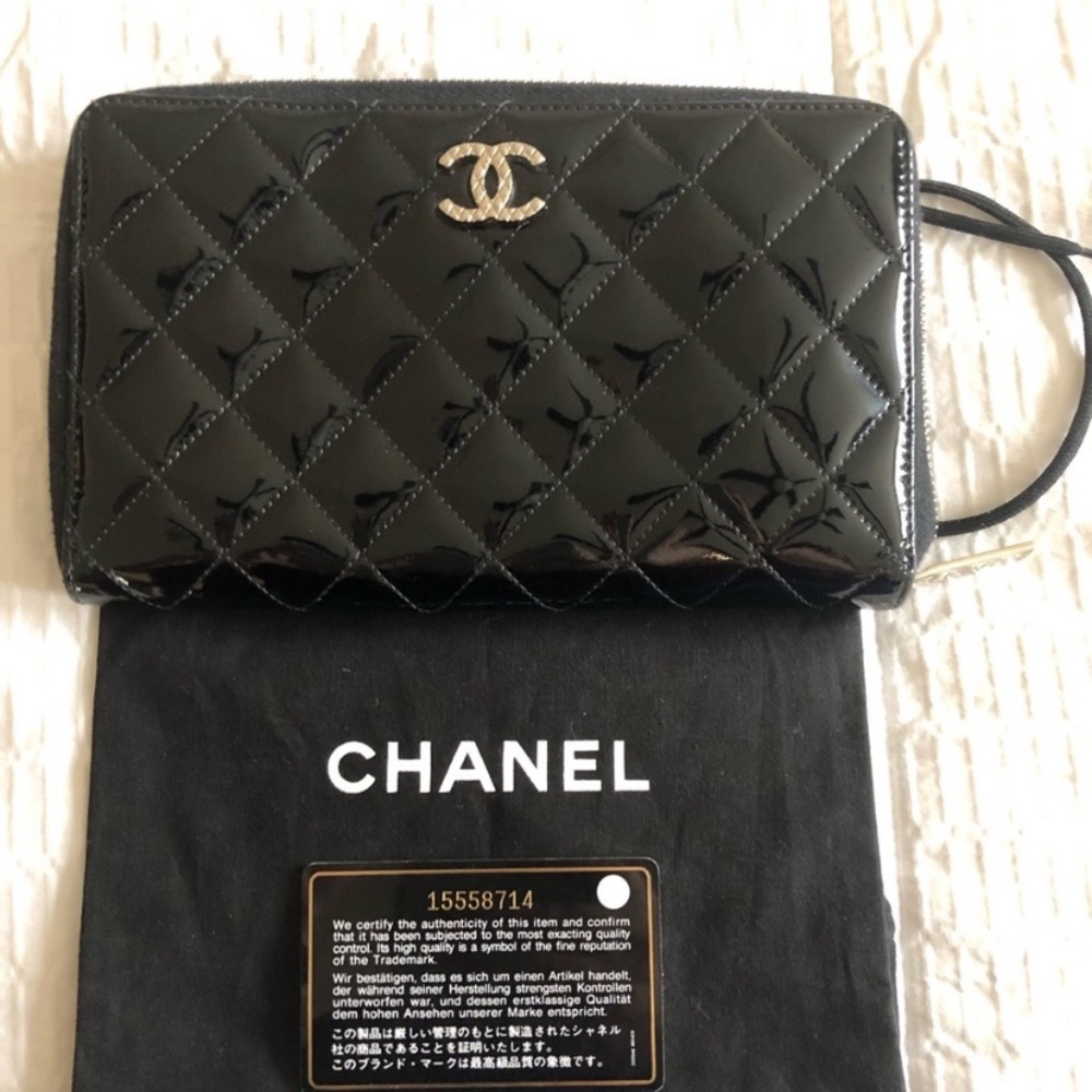 CHANEL Black, quilted patent leather wallet.